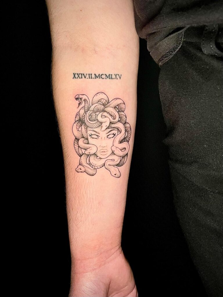 Stinging Bee Tattoostudio Miltenberg - Medusa Schlangenkopf mit Gesicht und Römischen Zahlen - Tättowierung auf der Rückseite des Unterarms